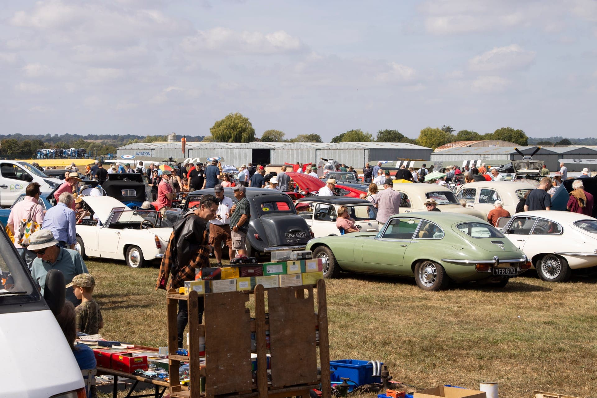 Wide shot of Wings & Wheels showing aircraft, vehicles, and crowds enjoying the day